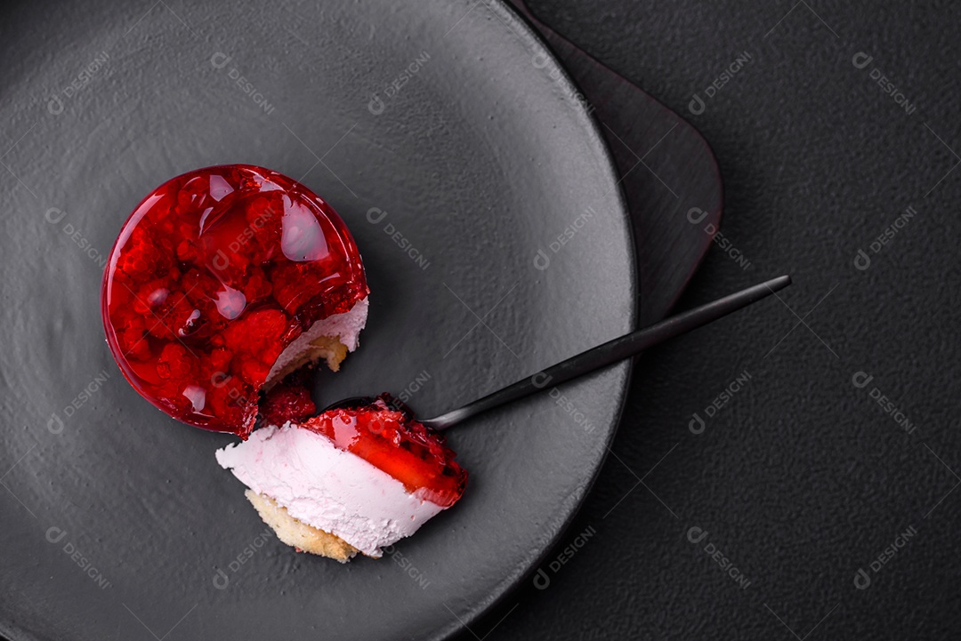 Delicioso bolo de queijo doce fresco com frutas e geleia de cor vermelha sobre um fundo escuro de concreto