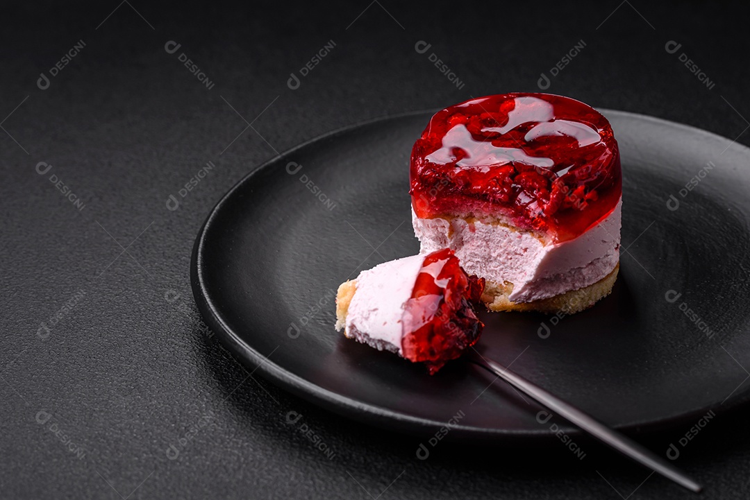 Delicioso bolo de queijo doce fresco com frutas e geleia de cor vermelha sobre um fundo escuro de concreto