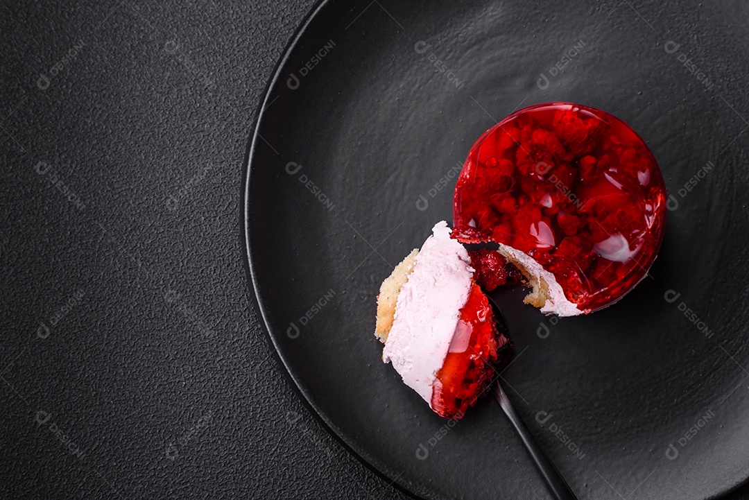 Delicioso bolo de queijo doce fresco com frutas e geleia de cor vermelha sobre um fundo escuro de concreto