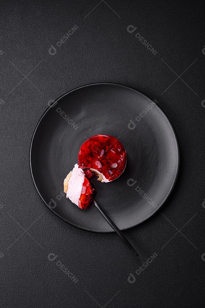 Delicioso bolo de queijo doce fresco com frutas e geleia de cor vermelha sobre um fundo escuro de concreto