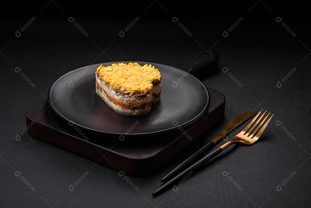 Deliciosa salada de mimosa fresca com conservas de peixe, ovo, moinese, queijo, sal e especiarias sobre fundo escuro de concreto