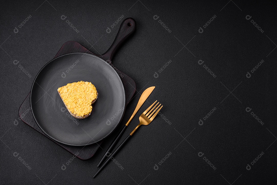 Deliciosa salada de mimosa fresca com conservas de peixe, ovo, moinese, queijo, sal e especiarias sobre fundo escuro de concreto