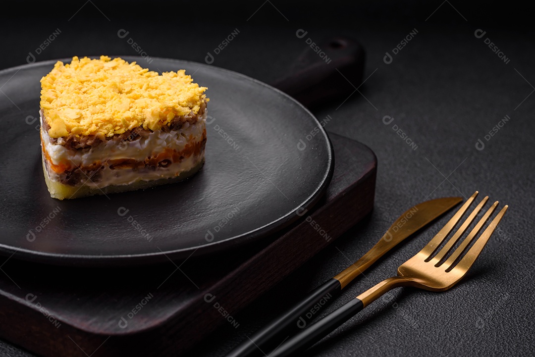 Deliciosa salada de mimosa fresca com conservas de peixe, ovo, moinese, queijo, sal e especiarias sobre fundo escuro de concreto