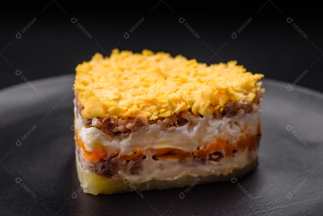 Deliciosa salada de mimosa fresca com conservas de peixe, ovo, moinese, queijo, sal e especiarias sobre fundo escuro de concreto