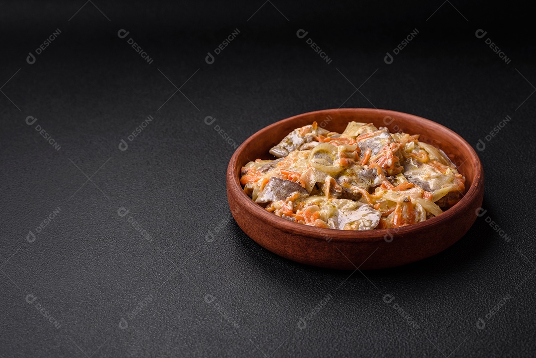 Deliciosa língua de carne cozida ou de porco cortada com cenouras, cebolas, creme de leite e especiarias num prato cerâmico