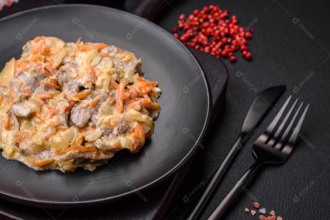 Deliciosa língua de carne cozida ou de porco cortada com cenouras, cebolas, creme de leite e especiarias num prato cerâmico