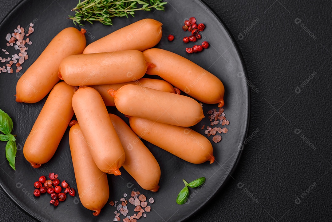 Deliciosas salsichas frescas cozidas com sal, especiarias e ervas sobre um fundo escuro de concreto