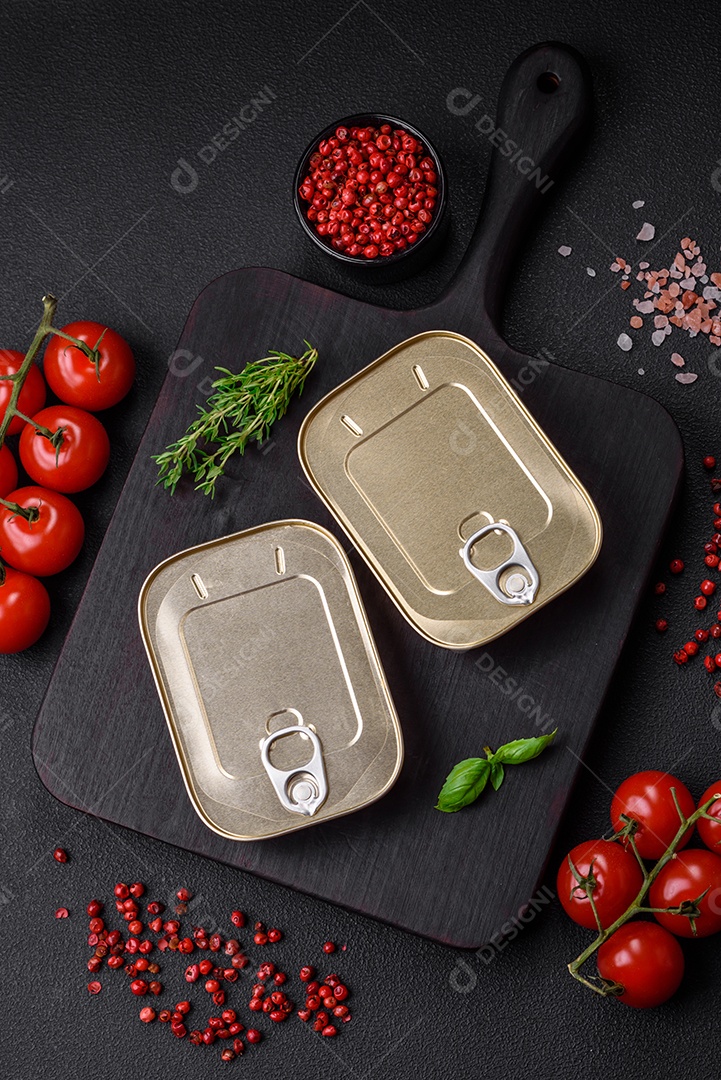 Lata retangular de estanho ou alumínio de alimentos enlatados com uma chave sobre um fundo escuro de concreto