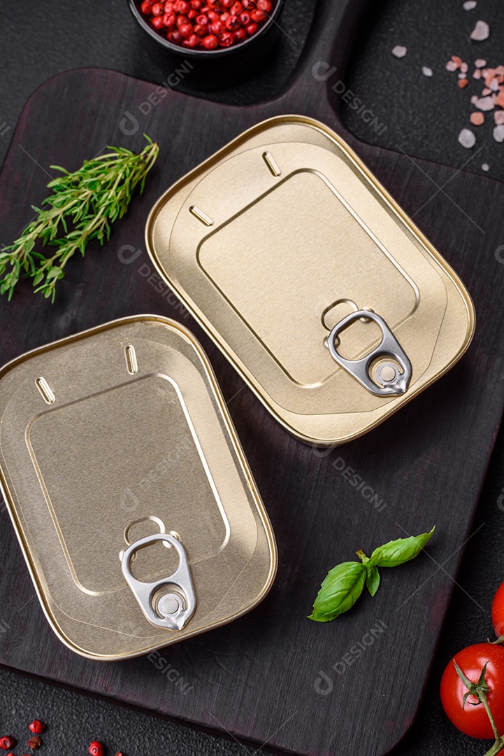 Lata retangular de estanho ou alumínio de alimentos enlatados com uma chave sobre um fundo escuro de concreto