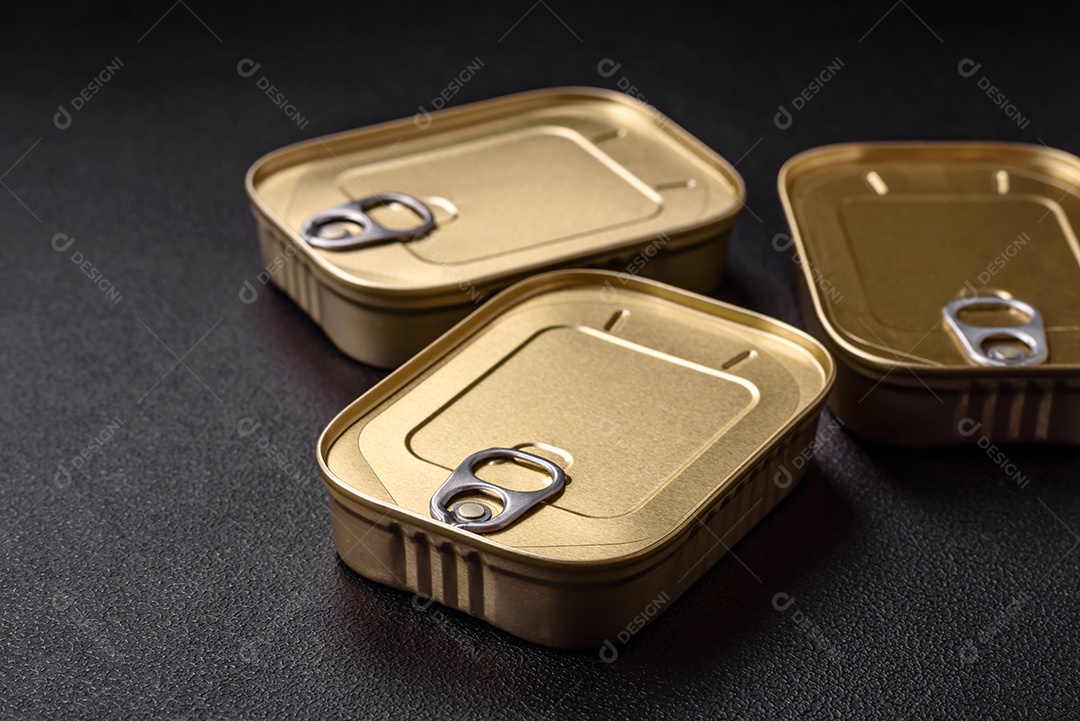 Lata retangular de estanho ou alumínio de alimentos enlatados com uma chave sobre um fundo escuro de concreto