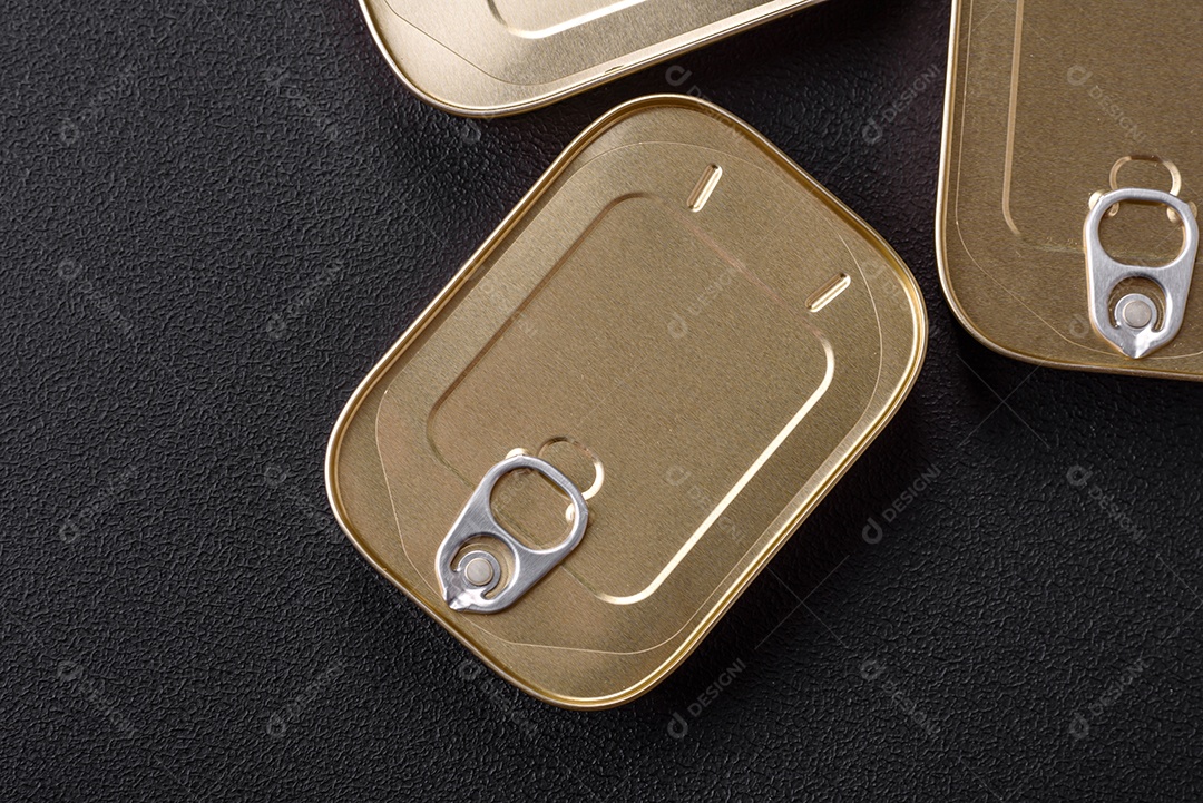 Lata retangular de estanho ou alumínio de alimentos enlatados com uma chave sobre um fundo escuro de concreto