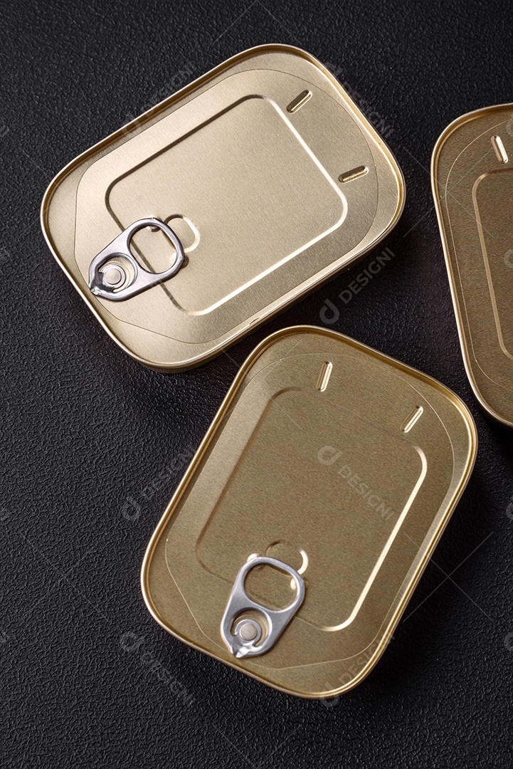 Lata retangular de estanho ou alumínio de alimentos enlatados com uma chave sobre um fundo escuro de concreto