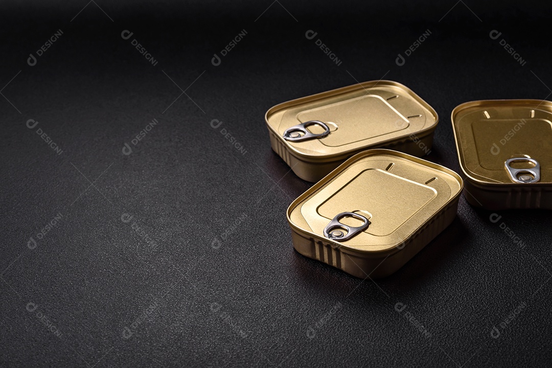 Lata retangular de estanho ou alumínio de alimentos enlatados com uma chave sobre um fundo escuro de concreto