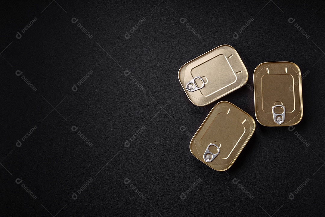 Lata retangular de estanho ou alumínio de alimentos enlatados com uma chave sobre um fundo escuro de concreto