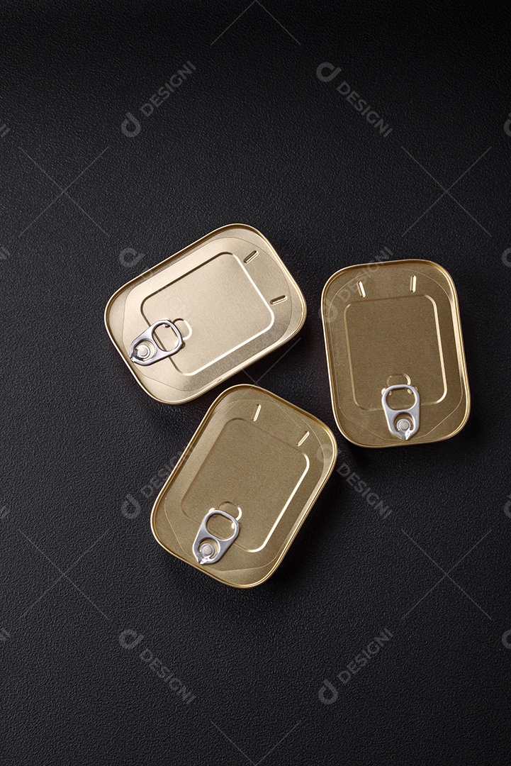 Lata retangular de estanho ou alumínio de alimentos enlatados com uma chave sobre um fundo escuro de concreto