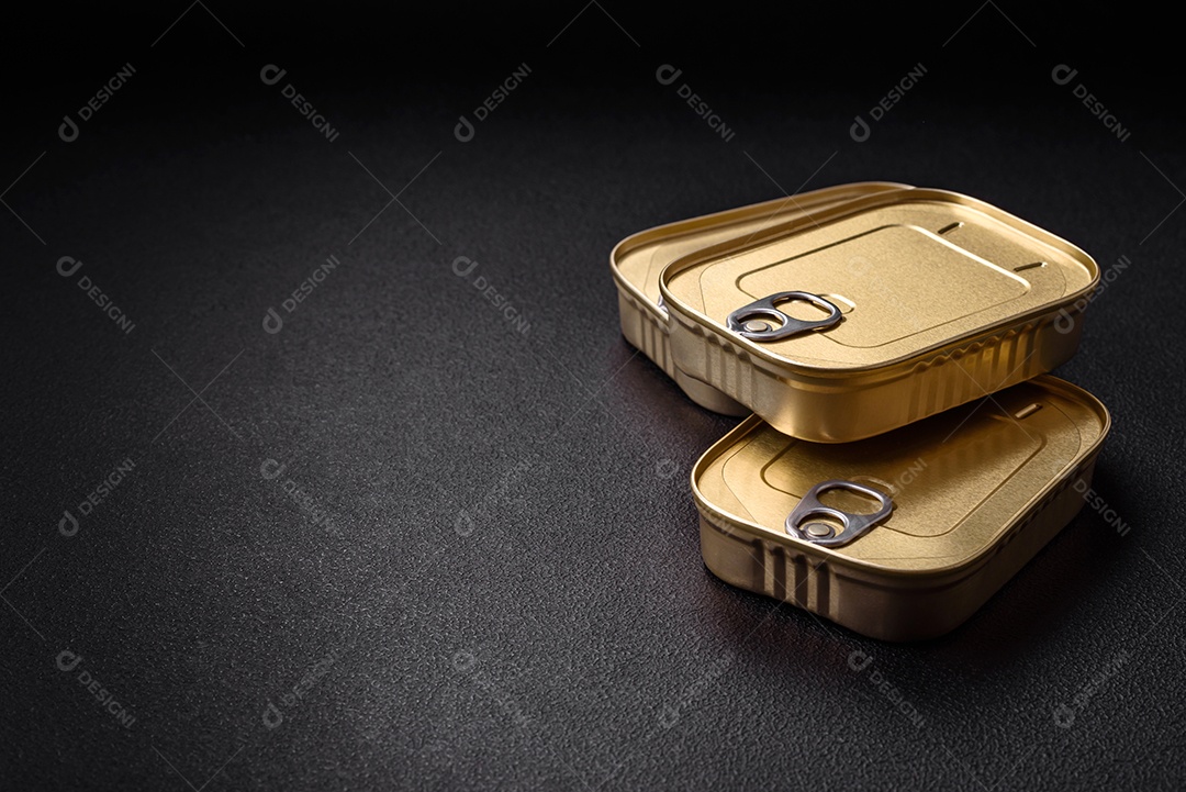 Lata retangular de estanho ou alumínio de alimentos enlatados com uma chave sobre um fundo escuro de concreto