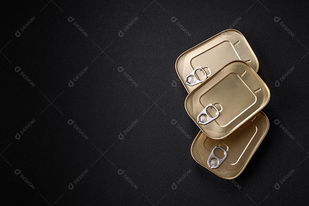 Lata retangular de estanho ou alumínio de alimentos enlatados com uma chave sobre um fundo escuro de concreto