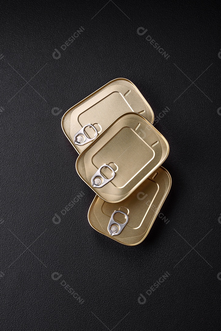 Lata retangular de estanho ou alumínio de alimentos enlatados com uma chave sobre um fundo escuro de concreto