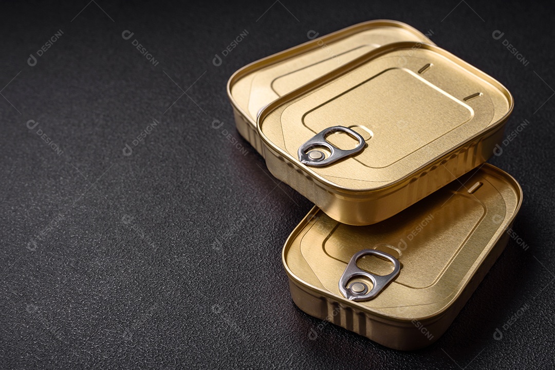 Lata retangular de estanho ou alumínio de alimentos enlatados com uma chave sobre um fundo escuro de concreto