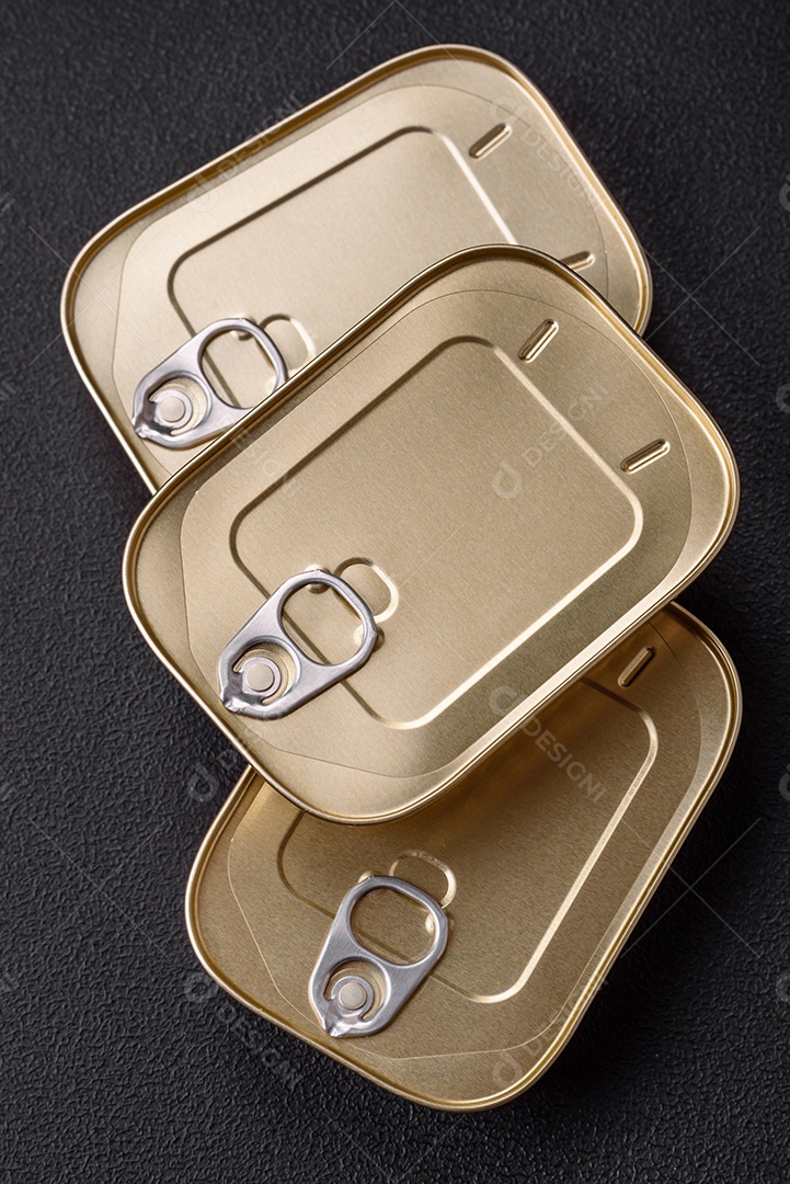 Lata retangular de estanho ou alumínio de alimentos enlatados com uma chave sobre um fundo escuro de concreto