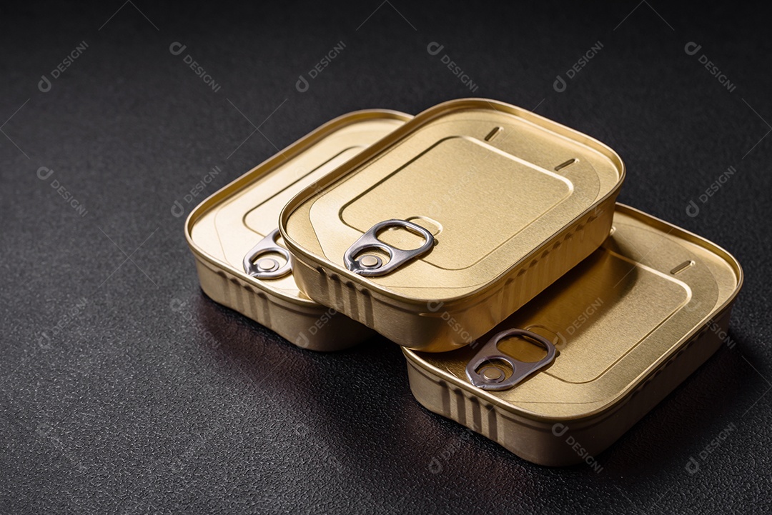 Lata retangular de estanho ou alumínio de alimentos enlatados com uma chave sobre um fundo escuro de concreto