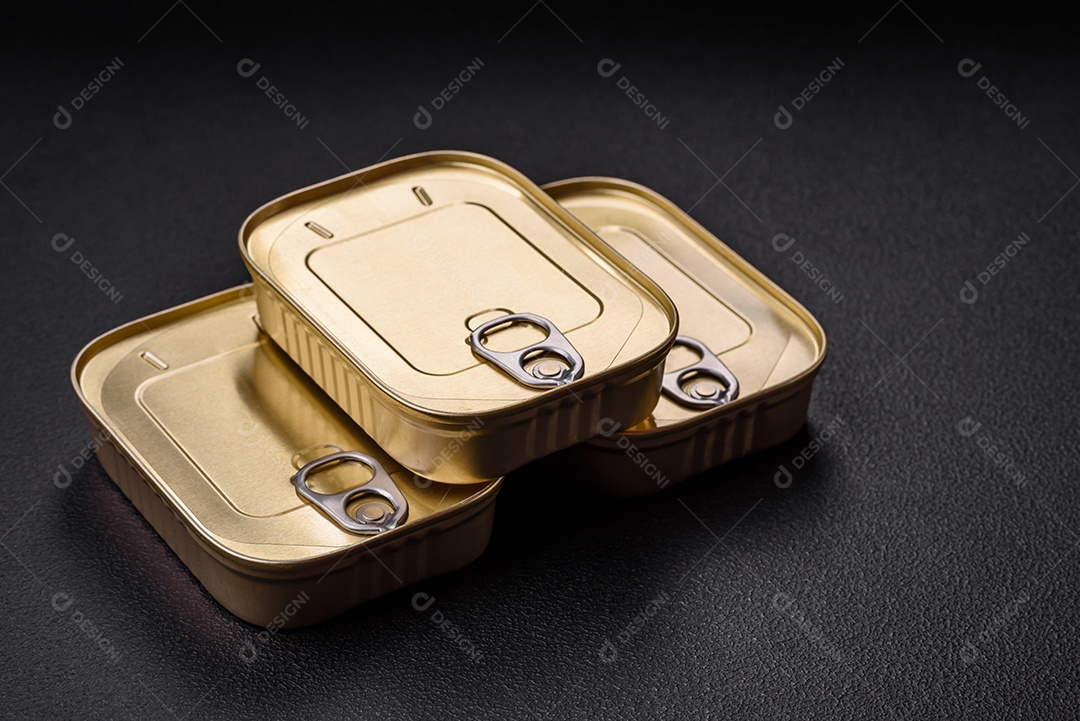 Lata retangular de estanho ou alumínio de alimentos enlatados com uma chave sobre um fundo escuro de concreto