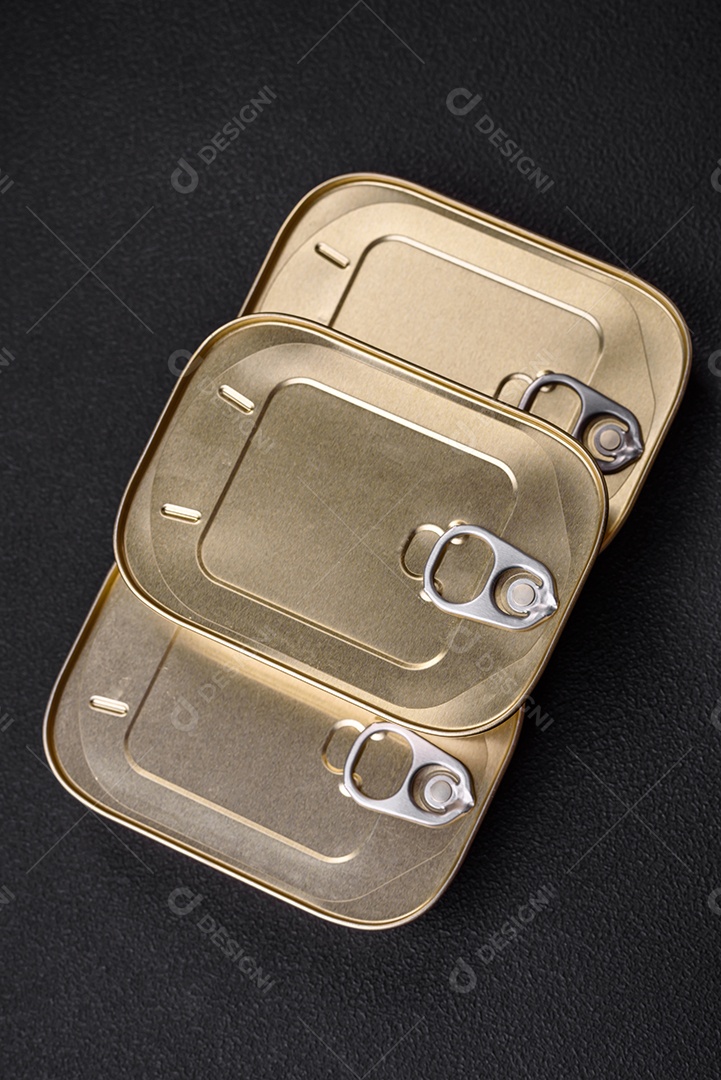 Lata retangular de estanho ou alumínio de alimentos enlatados com uma chave sobre um fundo escuro de concreto