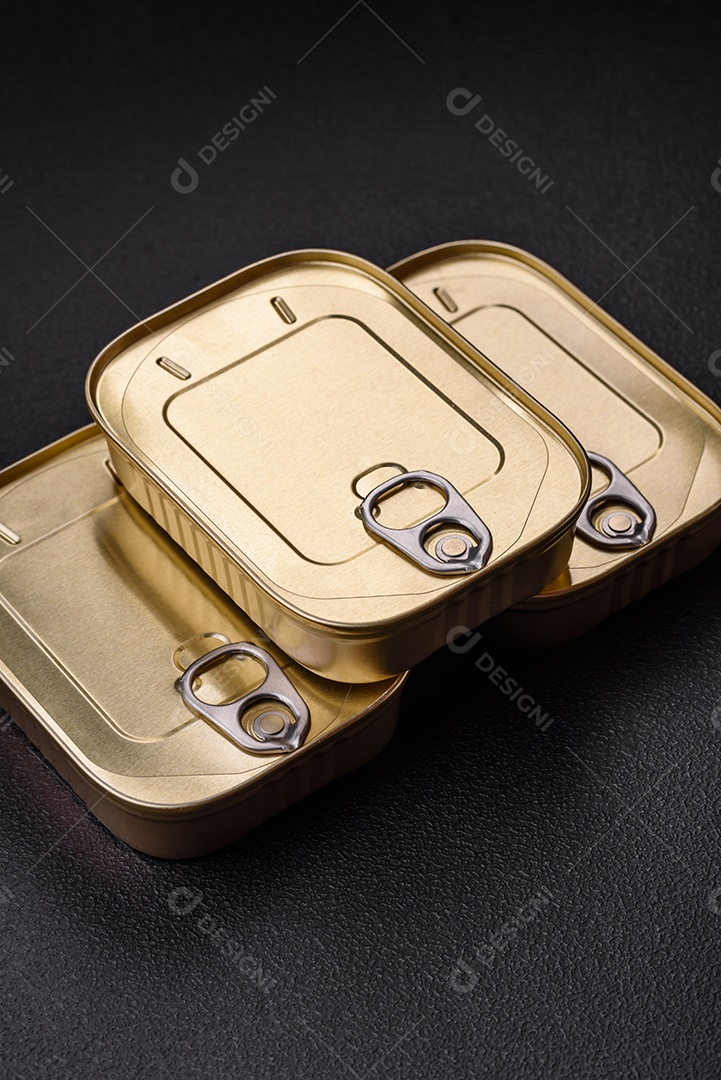 Lata retangular de estanho ou alumínio de alimentos enlatados com uma chave sobre um fundo escuro de concreto