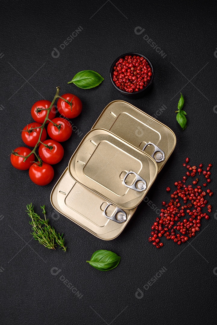 Lata retangular de estanho ou alumínio de alimentos enlatados com uma chave sobre um fundo escuro de concreto