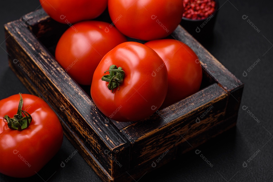Deliciosos tomates suculentos frescos em um fundo escuro de concreto. Ingredientes do molho