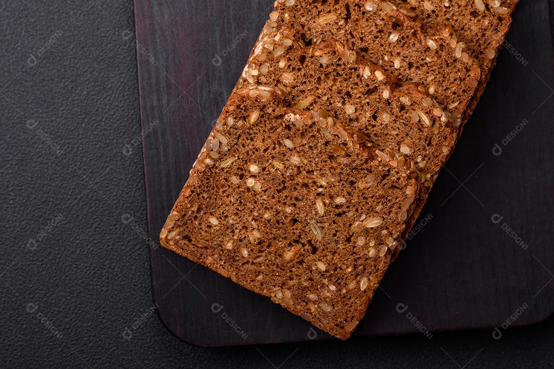 Delicioso  fresco e crocante com sementes e grãos cortados em fatias sobre um fundo escuro de concreto