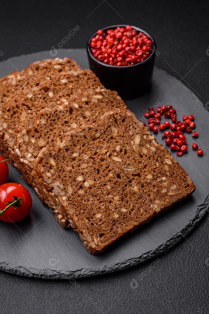 Delicioso  fresco e crocante com sementes e grãos cortados em fatias sobre um fundo escuro de concreto