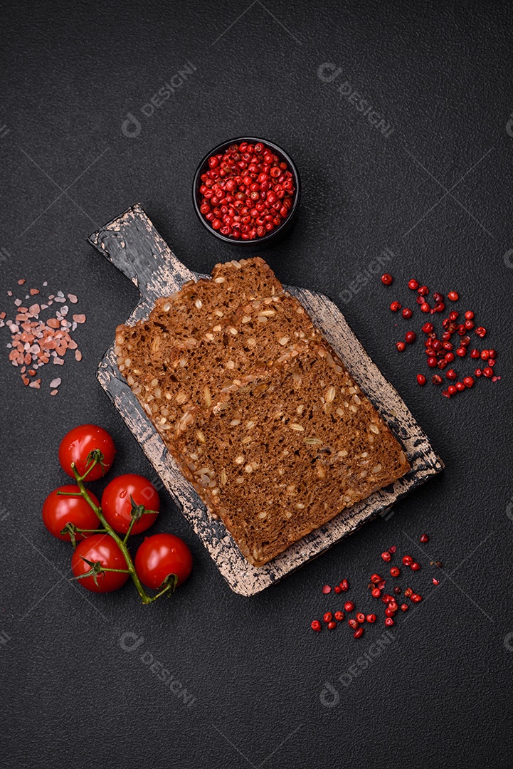 Delicioso  fresco e crocante com sementes e grãos cortados em fatias sobre um fundo escuro de concreto