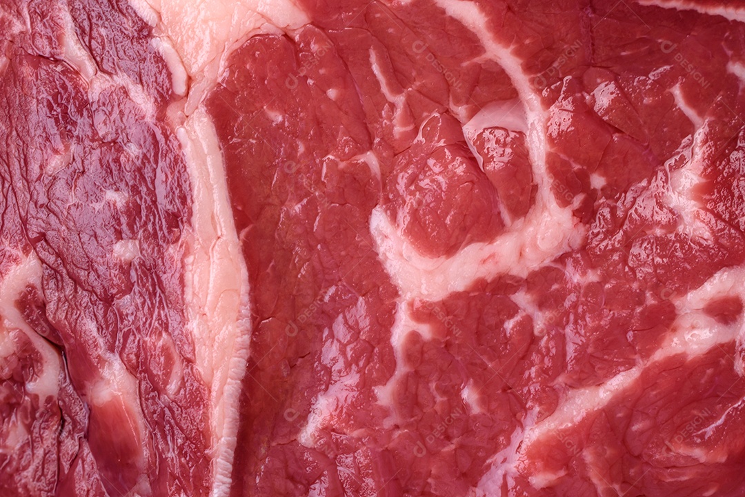 Bife fresco e cru com sal, especiarias e ervas em um fundo escuro e texturizado