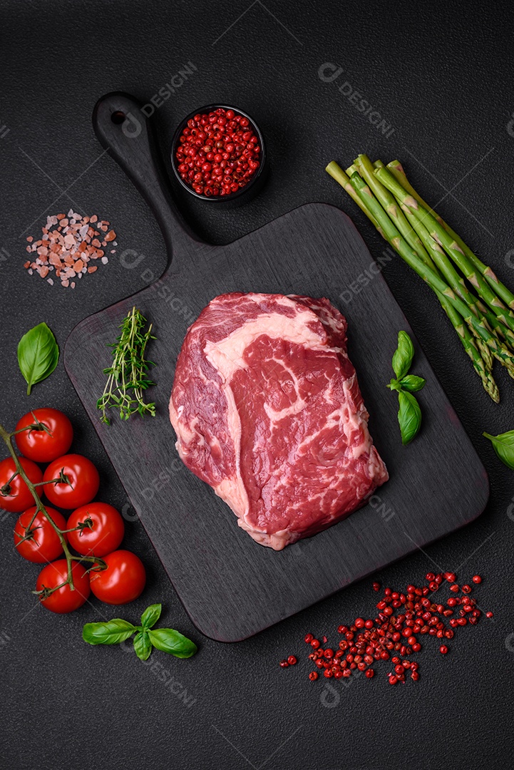 Bife fresco e cru com sal, especiarias e ervas em um fundo escuro e texturizado