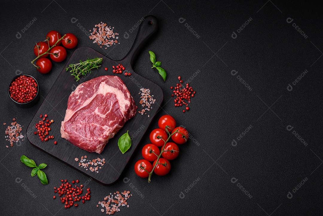 Bife fresco e cru com sal, especiarias e ervas em um fundo escuro e texturizado