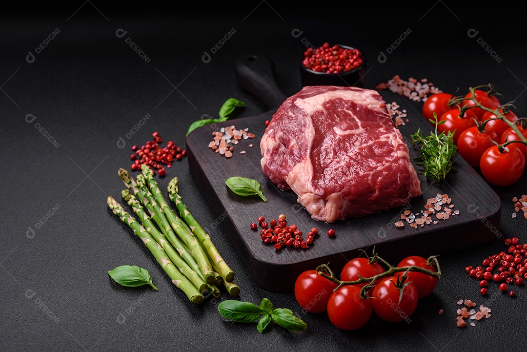 Bife fresco e cru com sal, especiarias e ervas em um fundo escuro e texturizado