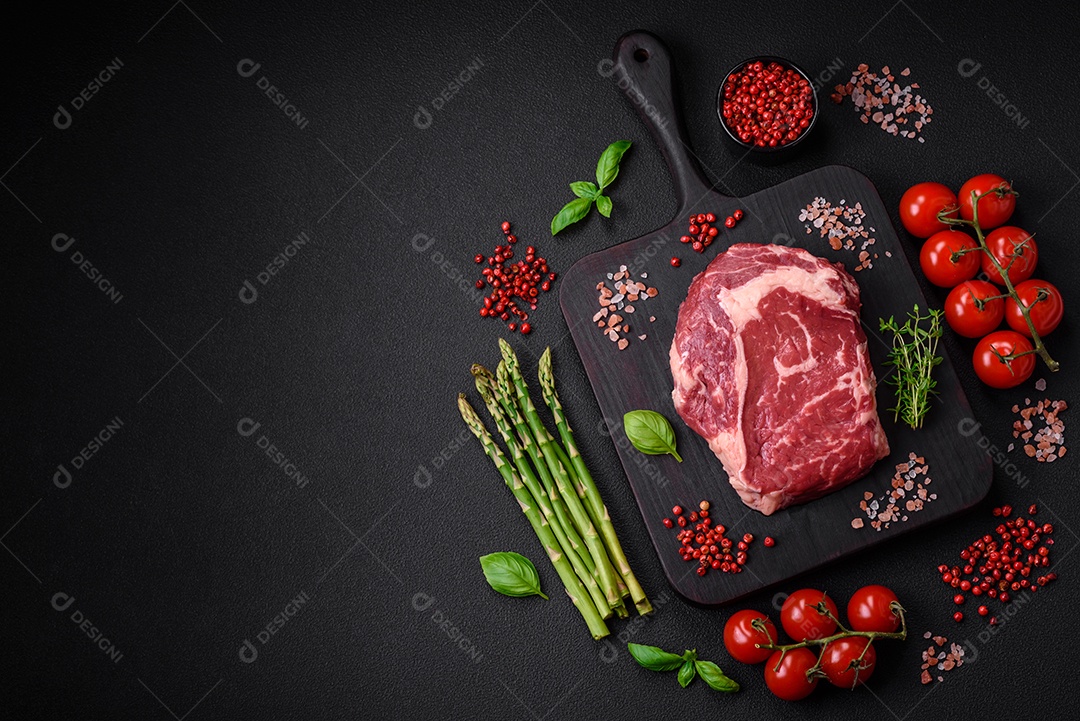 Bife fresco e cru com sal, especiarias e ervas em um fundo escuro e texturizado