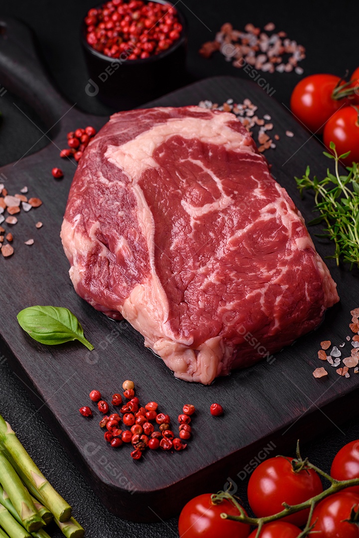 Bife fresco e cru com sal, especiarias e ervas em um fundo escuro e texturizado