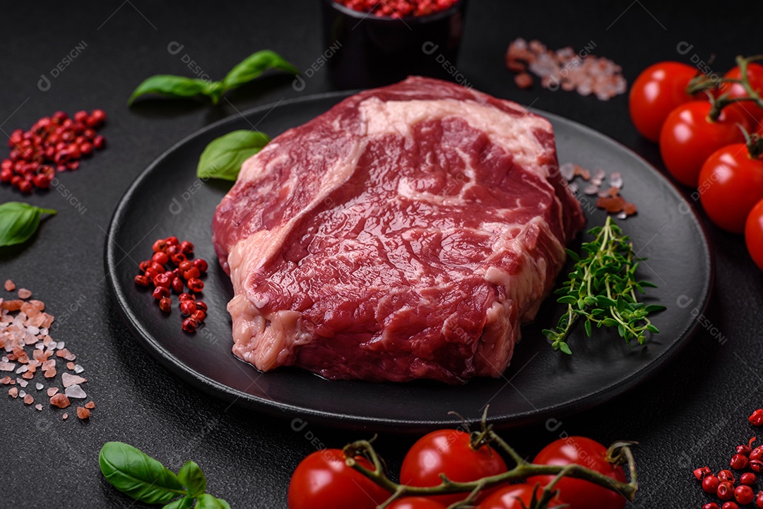 Bife fresco e cru com sal, especiarias e ervas em um fundo escuro e texturizado