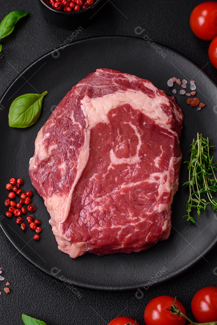 Bife fresco e cru com sal, especiarias e ervas em um fundo escuro e texturizado