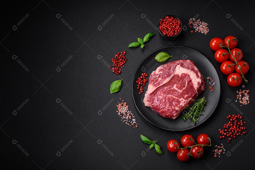 Bife fresco e cru com sal, especiarias e ervas em um fundo escuro e texturizado