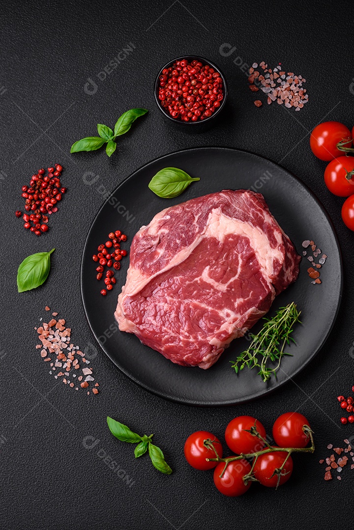 Bife fresco e cru com sal, especiarias e ervas em um fundo escuro e texturizado