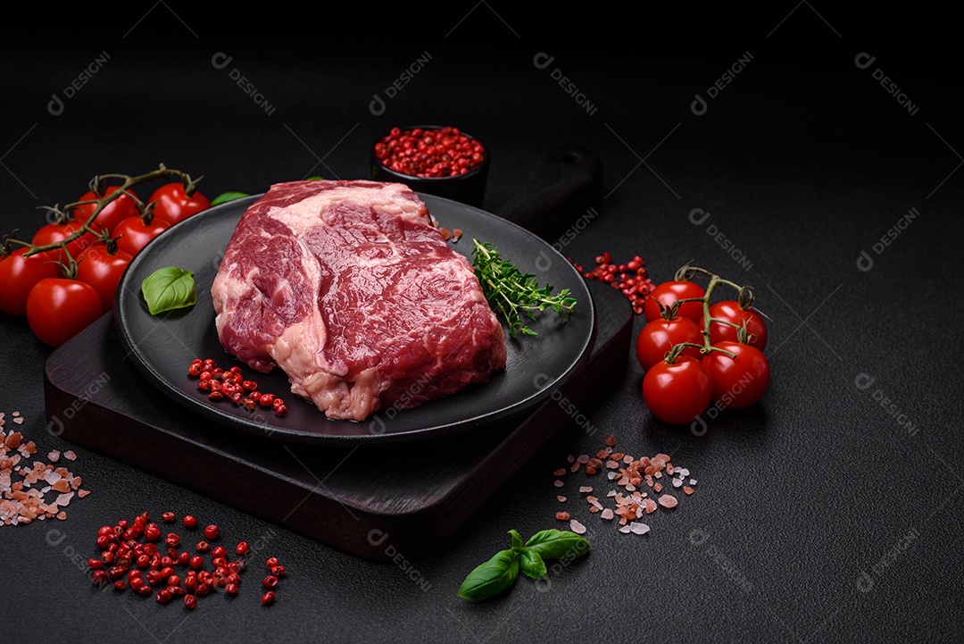 Bife fresco e cru com sal, especiarias e ervas em um fundo escuro e texturizado