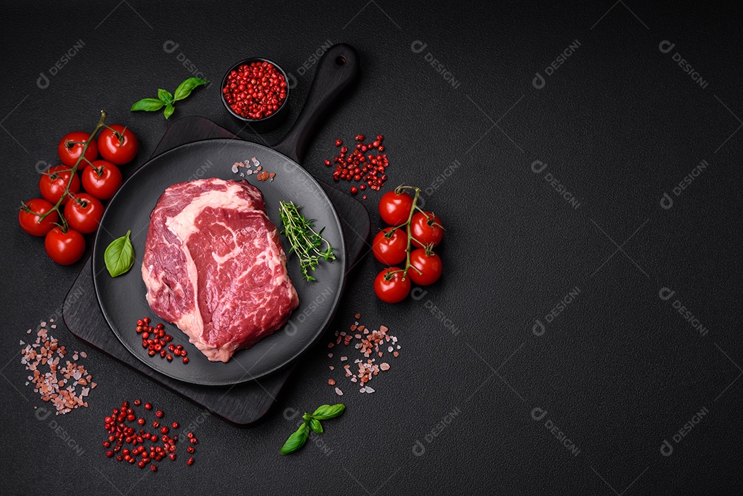 Bife fresco e cru com sal, especiarias e ervas em um fundo escuro e texturizado