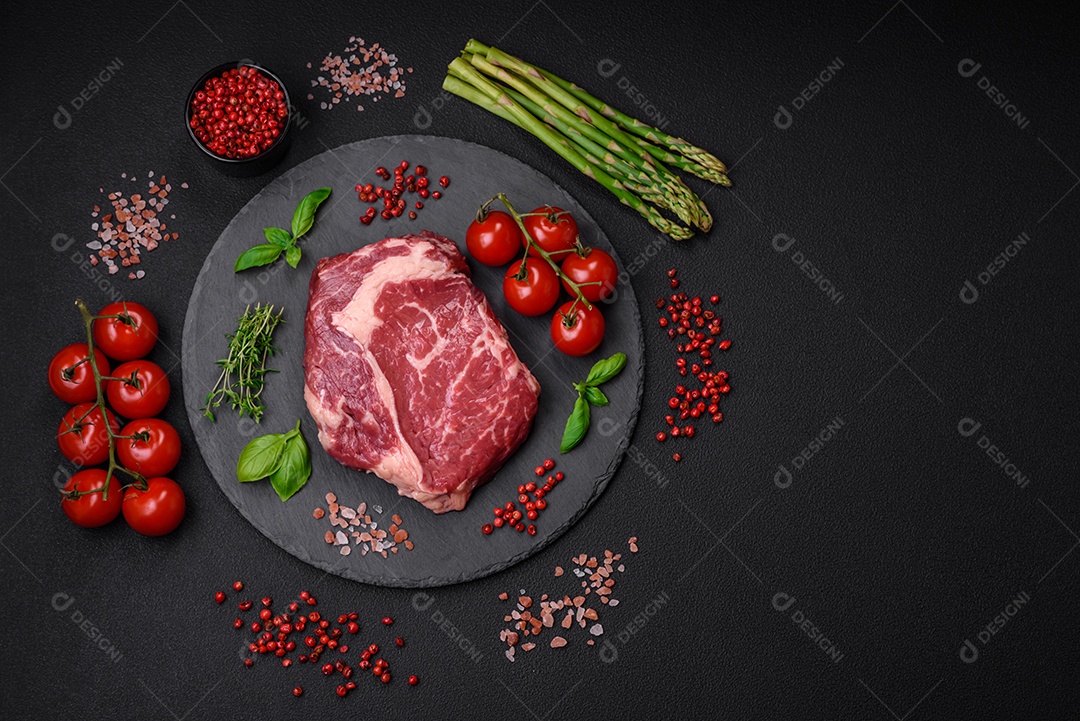Bife fresco e cru com sal, especiarias e ervas em um fundo escuro e texturizado