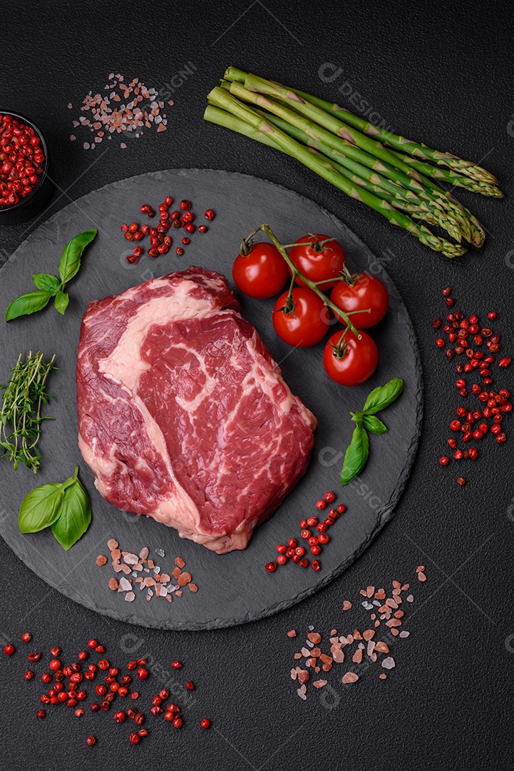 Bife fresco e cru com sal, especiarias e ervas em um fundo escuro e texturizado