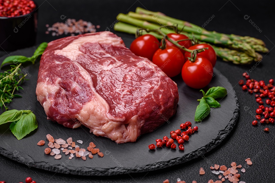 Bife fresco e cru com sal, especiarias e ervas em um fundo escuro e texturizado