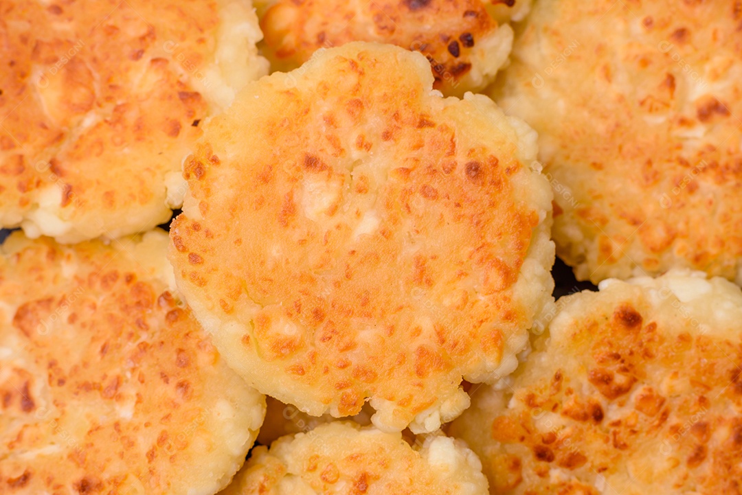 Deliciosos cheesecakes frescos com passas e baunilha em uma placa de cerâmica preta sobre um fundo escuro de concreto