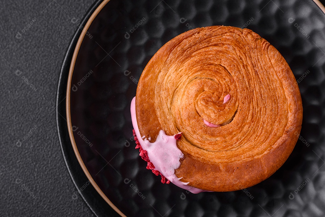 Croissant redondo de massa folhada com recheio de framboesa ou rolo de Nova Iorque sobre fundo escuro de concreto